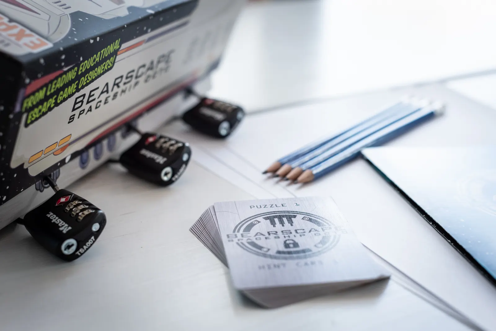 The Bearscape spaceship box with puzzle cards and pencils laid out on a table
