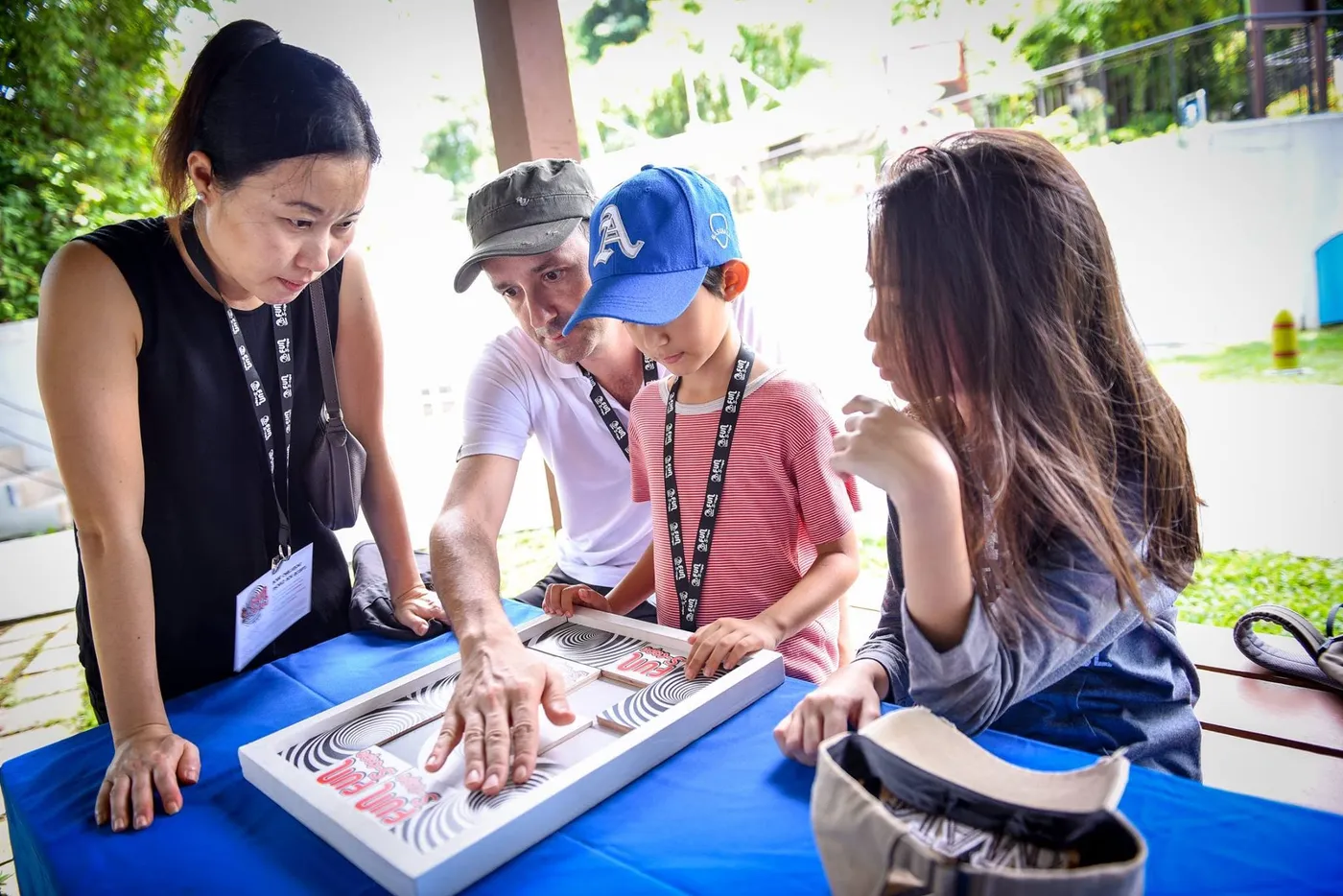 A family working a Fun-S-Cape puzzle table at the Sentosa carnival